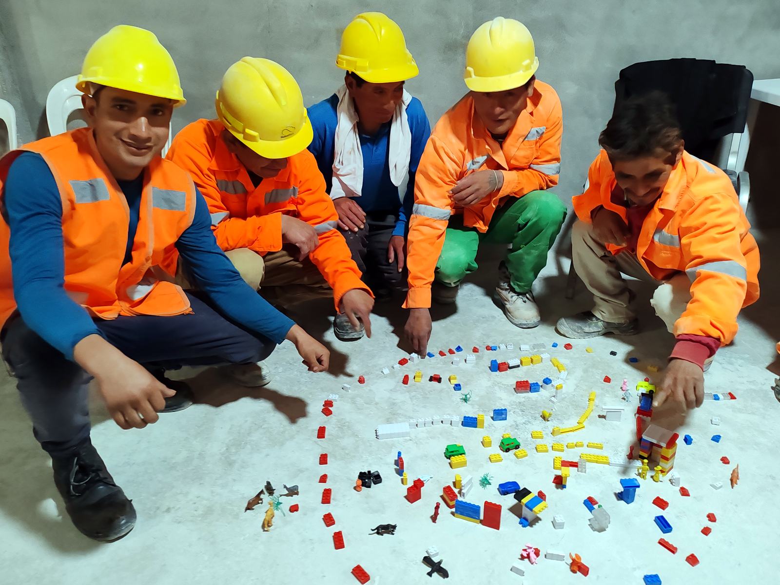Trabajadores con cascos y chalecos en una dinámica de seguridad y salud en el trabajo